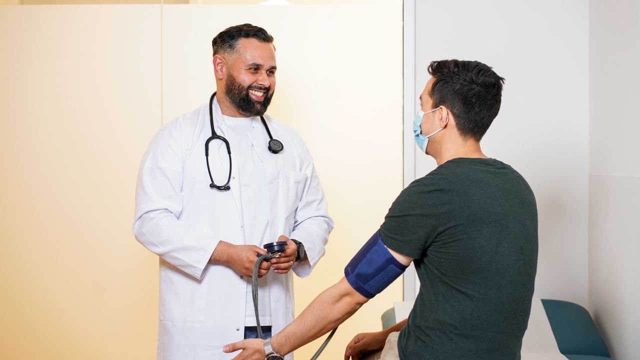 A doctor is smiling during the checkup of a guy
