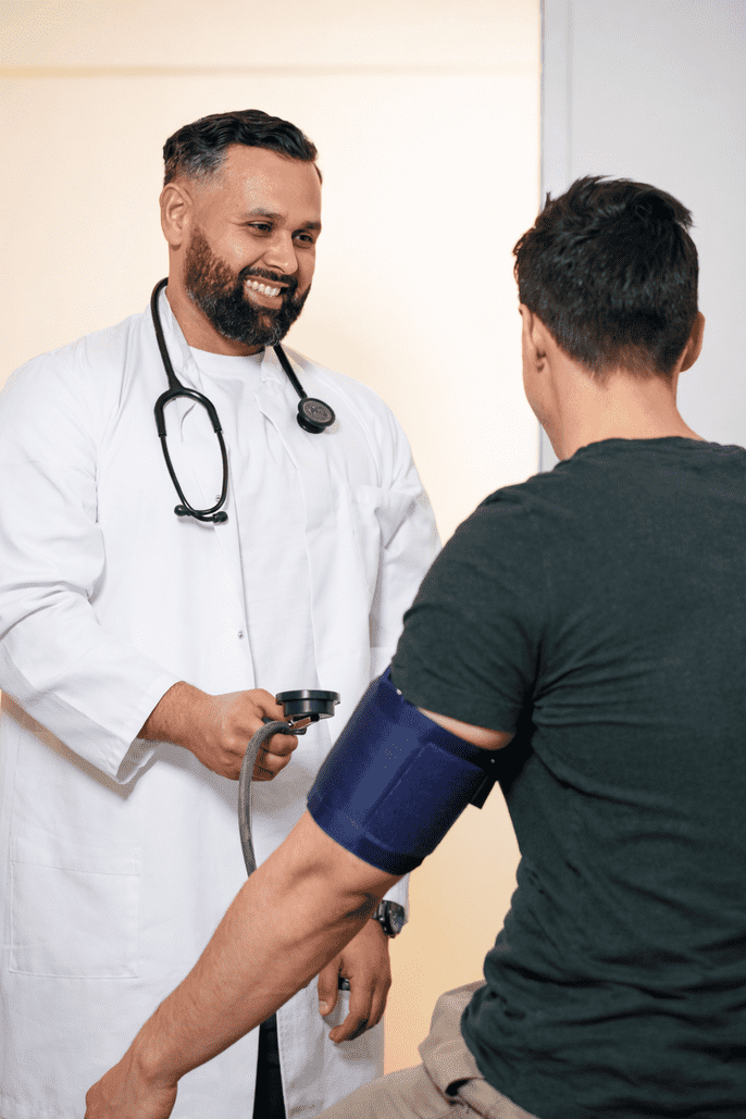 Arzt misst den Blutdruck eines männlichen Patienten in einer modernen Praxis